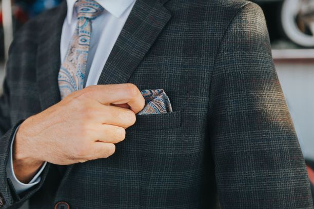 特写镜头是一个穿着深灰色格纹西装的男人，口袋里有一张纸巾图片下载