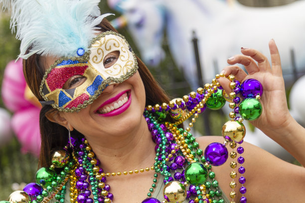 一位年轻的拉丁女游客，戴着面具，穿着服装，戴着项链，在新奥尔良的街道上庆祝狂欢节。图片下载