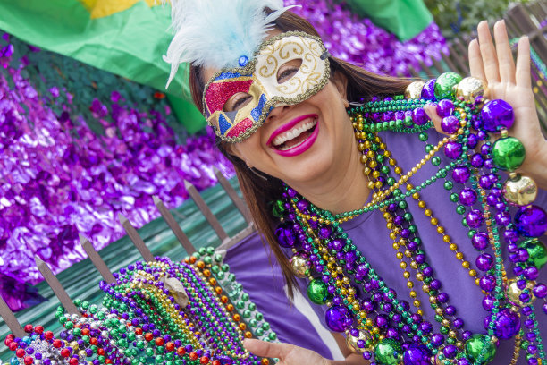 一位年轻的拉丁女游客，戴着面具，穿着服装，戴着项链，在新奥尔良的街道上庆祝狂欢节。图片下载