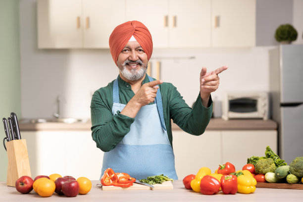 在厨房里戴头巾的成熟锡克教男子，库存照片图片下载