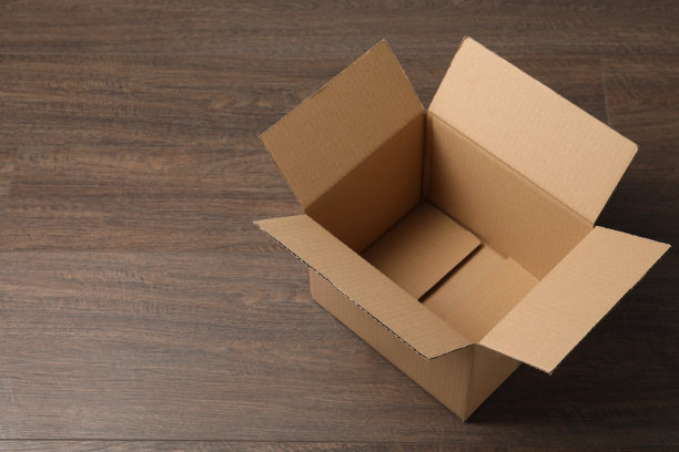 把打开的纸板箱倒在木桌上。文本空间图片下载