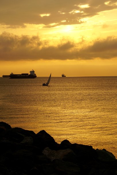 符拉迪沃斯托克市的青铜日落和海上的工业船只。海上绚丽的青铜日落。夕阳下的帆船在海上。图片下载