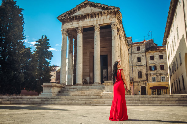 一位美丽的年轻女子站在一座古老的纪念碑旁图片下载