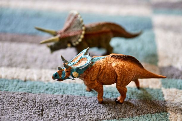 在地毯地板上有模糊背景的水银角玩具雕像的选择性聚焦镜头图片下载