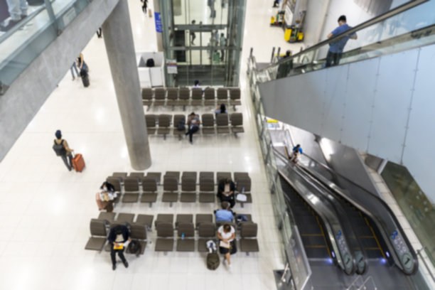 游客们坐在机场里，一边从高处观察，一边拍下朦胧的照片。模糊的照片。图片下载