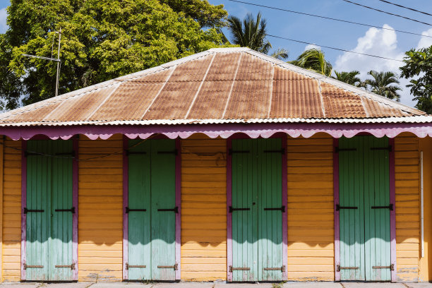 五彩缤纷的建筑前面有四扇相同的门和生锈的屋顶图片下载
