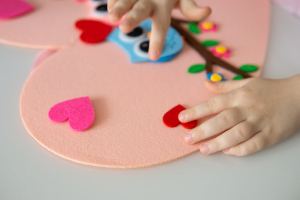 一个博主女孩为情人节制作了一个心形的毡工艺品。儿童创意和手工的概念。图片下载