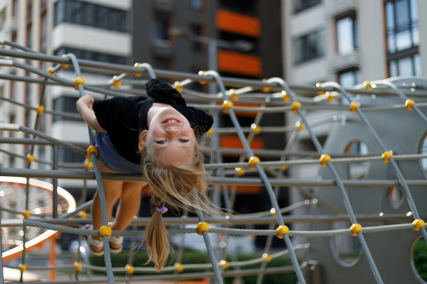小可爱的女孩在操场上玩得很开心。图片下载