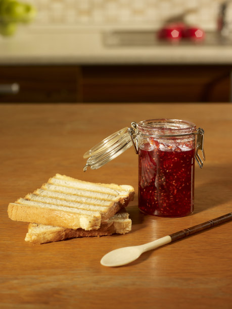 樱桃酱面包放在厨房桌子上图片下载