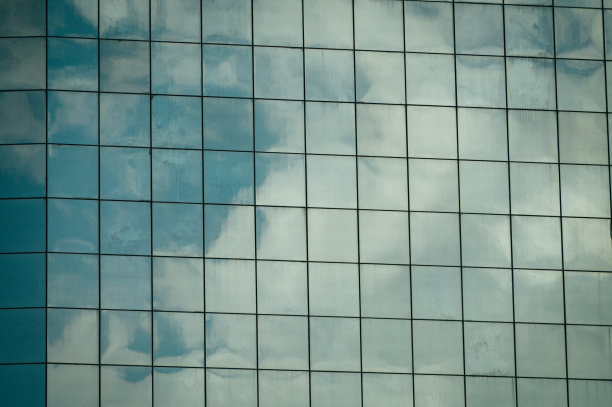 现代办公大楼，背景是多云的天空图片下载