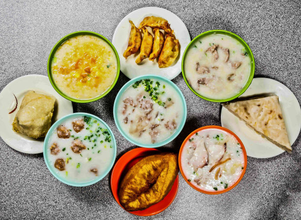 什锦粥，生猪卷，牛肉，肉丸，皮蛋瘦肉，鱼片，脆腿，南瓜粥，蒸胡萝卜糕，蛋黄培根炸饺子，香港美食的俯视图图片下载