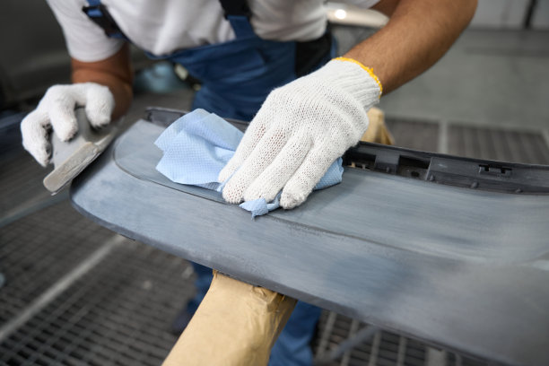 修理工在车库里喷漆前清洗汽车零件图片下载