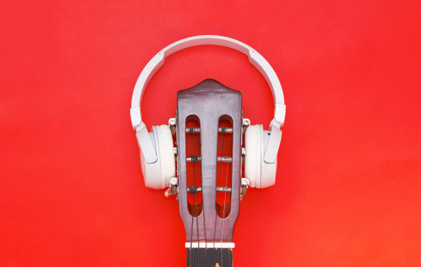 无线耳机在吉他上，红色背景。设计音乐封面。听古典音乐图片下载