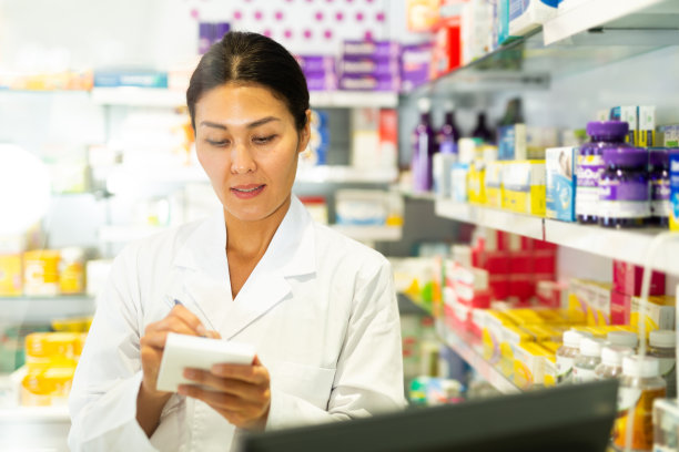 女药剂师在柜台写处方图片下载