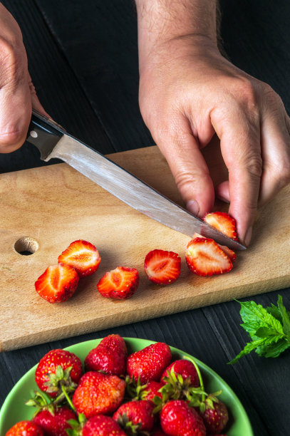 特写:厨师在餐厅厨房的砧板上切新鲜草莓，用来制作薄荷饮料图片下载