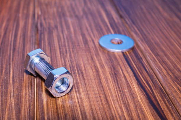 金属螺栓和螺母的复古木制背景图片下载