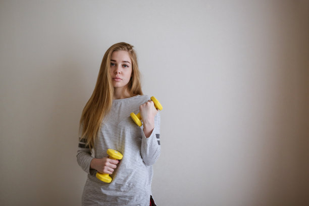 苗条的金发女孩，手里拿着哑铃，锻炼图片下载