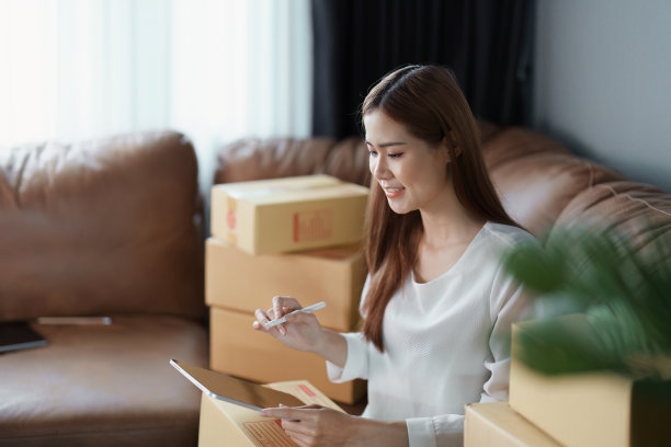 开始创业的独立年轻亚洲女性在线卖家使用平板电脑和订单包装产品交付给客户。中小企业交付概念图片下载