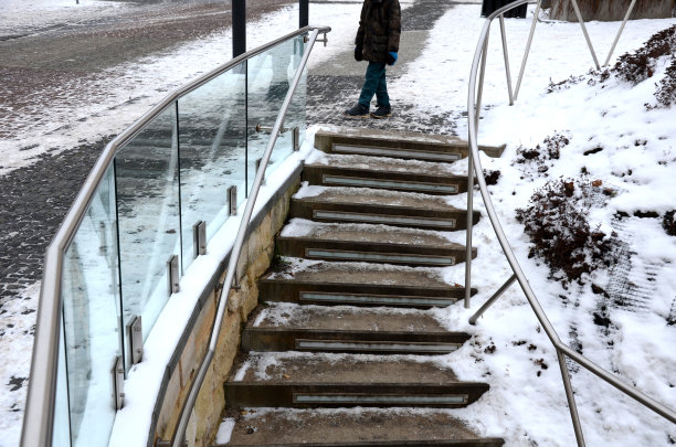 一幢豪华住宅的栏杆，由灰色金属不锈钢镶板固定的玻璃板组成。乳白色的磨砂玻璃屏障给人一种通风的印象。抛光金属盖，雪图片下载