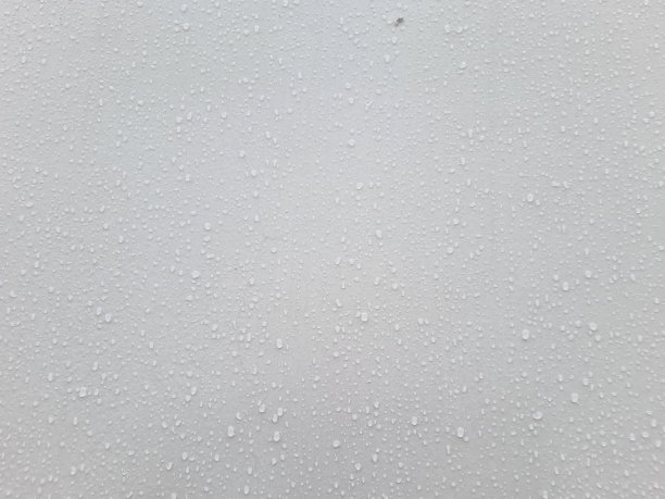 近距离暴露在雨滴下的湿白墙是制作背景和概念的完美选择图片下载