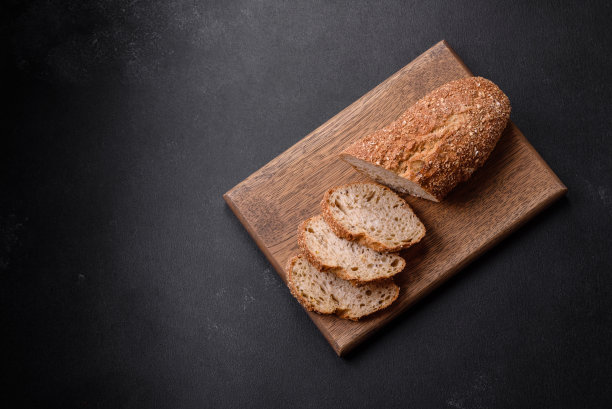 美味酥脆的面包和切成薄片的麦片放在木砧板上图片下载