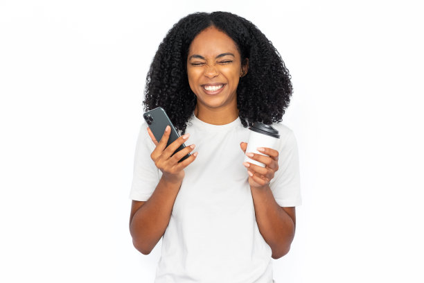 兴奋的多种族女性，拿着手机和咖啡图片下载