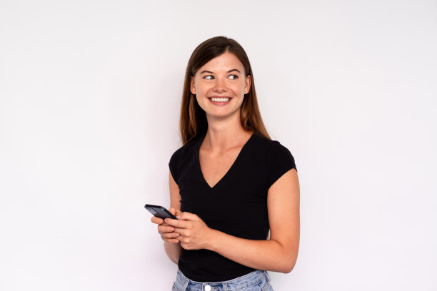 快乐的女人肖像使用手机和看向别处图片下载