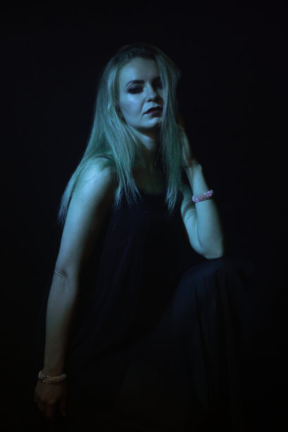 女人在黑暗中被绿光照亮图片下载