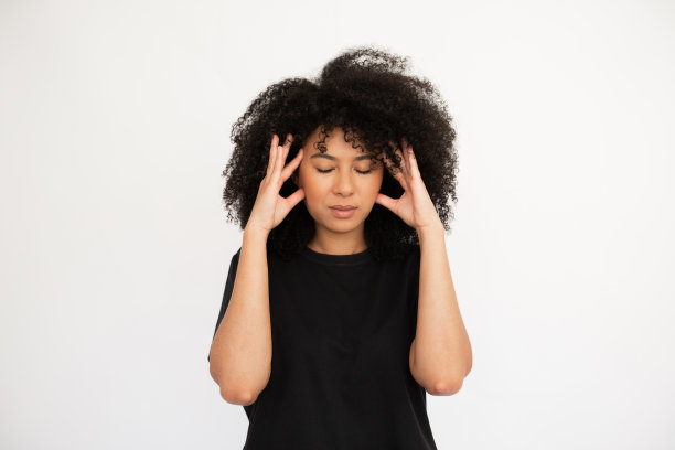 劳累过度的年轻女子按摩她的太阳穴图片下载