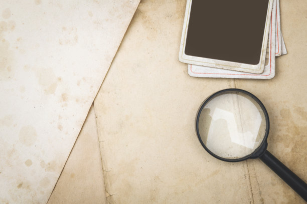 放大镜和相框放在旧纸上图片下载