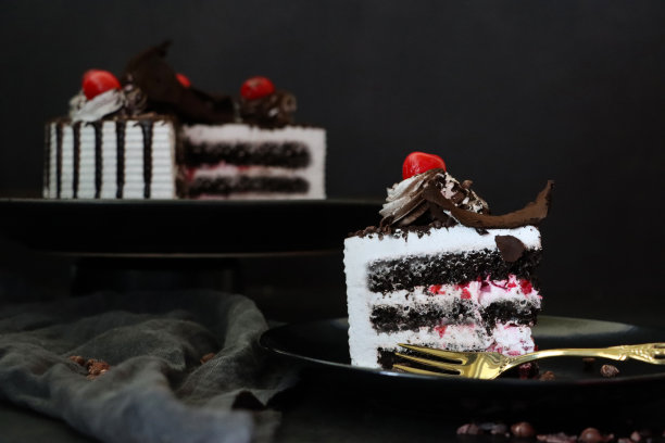 黑森林大门切片的图片，上面有莫雷罗樱桃，豪华的巧克力蛋糕上有奶油，上面覆盖着融化的巧克力，黑色背景，三层图片下载