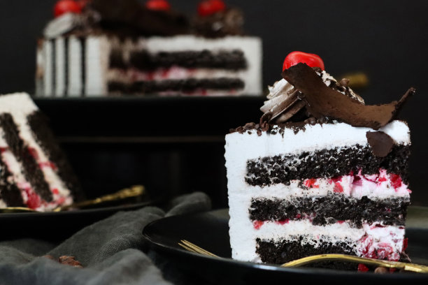 黑森林大门切片的图片，上面有莫雷罗樱桃，豪华的巧克力蛋糕上有奶油，上面覆盖着融化的巧克力，黑色背景，三层图片下载