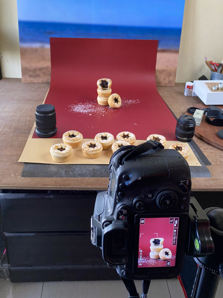 图片背后的美食摄影工作室的照片拍摄设置，拍摄室内的批量肉馅派，酥脆的糕点挞馅甜肉馅与数码单反相机，相机镜头，聚焦前景图片下载