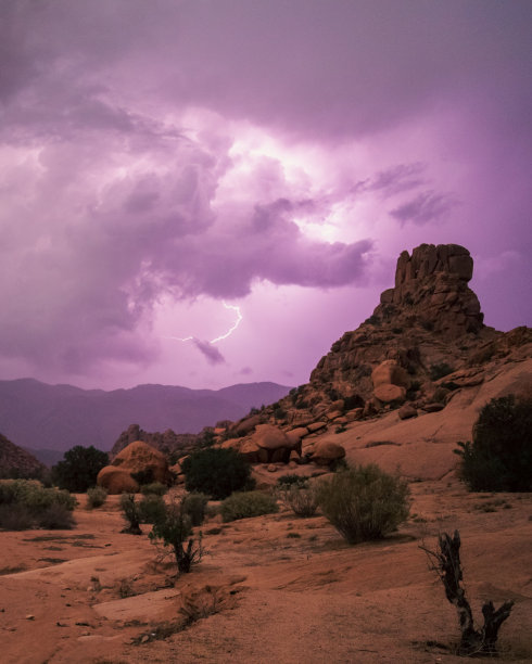 竖版照片：紫色天空与沙漠上方的闪电图片下载