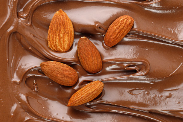 巧克力奶油杏仁坚果。酱，酱，糖浆。液体巧克力的背景。旋度。纹理，特写，俯视图。图片下载