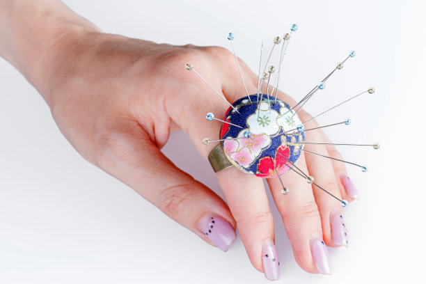 一种白色背景的戒指，手上有一个小针枕图片下载