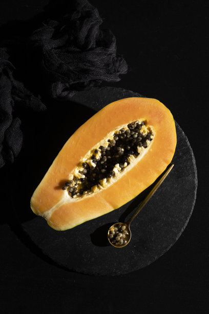 成熟和新鲜切开的木瓜。新鲜的热带水果和深色的背景图片下载