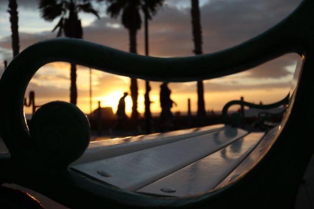 海滩日落，棕榈树在白色长凳和剪影前图片下载