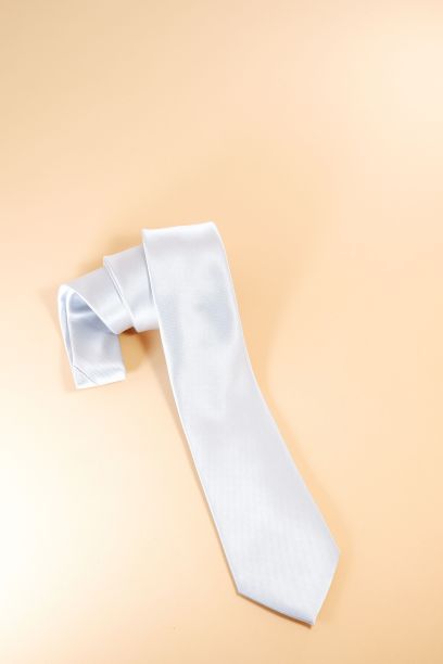 垂直拍摄的白色涤纶领带孤立在黄色背景上。图片下载