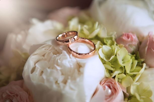 在一个孤立的背景上，新娘捧花上的金婚戒特写镜头图片下载