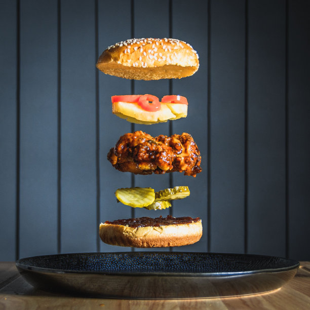 垂直拍摄的辣味鸡肉汉堡，小黄瓜、菠萝和辣椒堆叠在一起图片下载