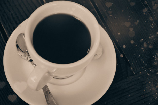 在情人节的时候，在有心形图案和散景灯光的木桌上喝一杯过滤咖啡或浓缩咖啡图片下载