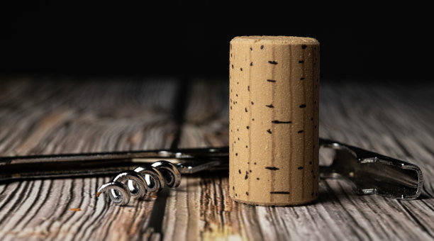 微距照片的软木塞和软木塞钻在木桌和黑暗的背景图片下载
