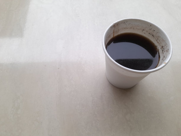 黑咖啡饮料在塑料杯顶部视图的木桌。图片下载