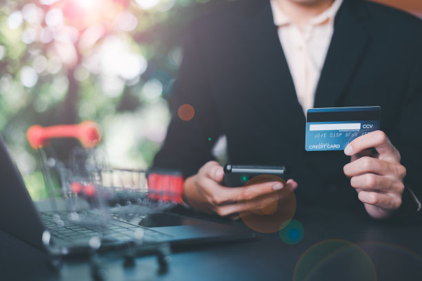 年轻的商人使用信用卡通过智能手机进行金融交易，无线通信技术的支付概念，关注消费者安全和无现金。图片下载