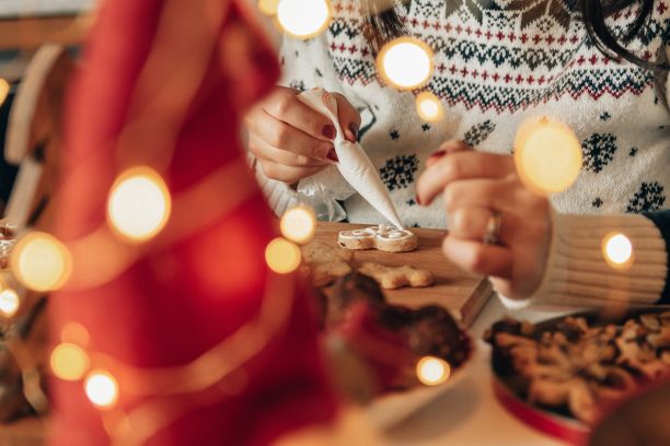 一个女人在家里装饰姜饼圣诞饼干的特写照片图片下载