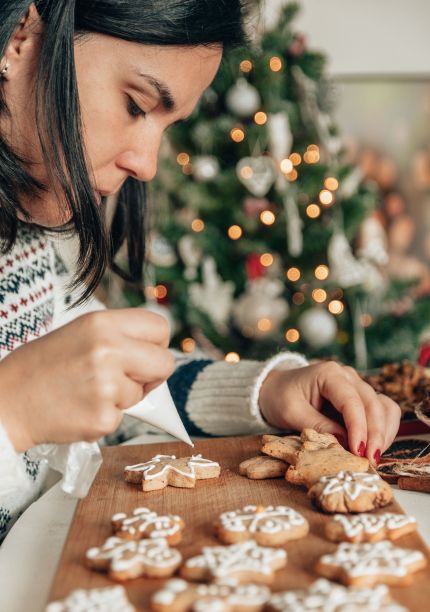 一个女人在家里装饰姜饼圣诞饼干的特写照片图片下载
