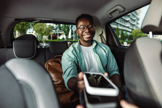 年轻人用智能手机支付打车费用图片下载