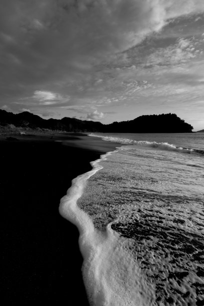 白色的海浪和黑色的沙滩图片下载