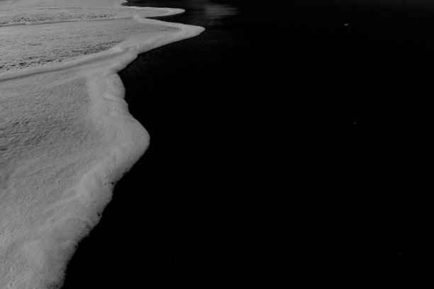 白色的海浪和黑色的沙滩图片下载